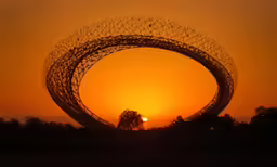 a large metal object with trees on the other side