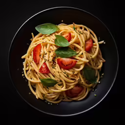 a plate of pasta with tomato and basil
