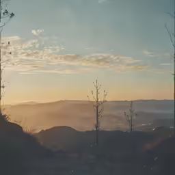 a beautiful view of hills, trees and sky