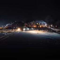 two cars are parked on the road in front of houses