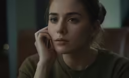 woman with serious look, leaning on cell phone