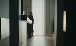 a woman standing in a room near a mirror