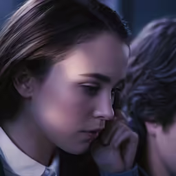 a woman in a suit staring at another man