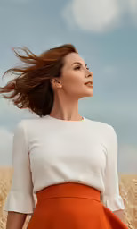 a woman in an orange skirt posing in a wheatfield