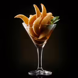 a martini drink filled with sliced orange peels