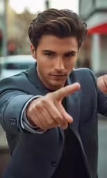 the young man is pointing at something while posing