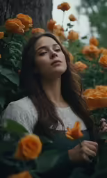 a young woman stands among flowers in the woods
