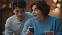 a woman and a man looking at something on a phone