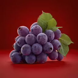 purple grapes with green leaves sit on a red surface