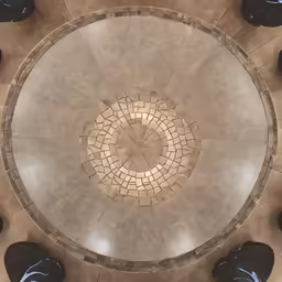 looking down at a round tile pattern in the floor of a building