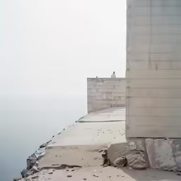 there is a tall building on the edge of the water