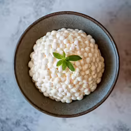 a bowl filled with a white substance and a green leaf