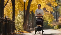 woman walking with baby in stroller in park