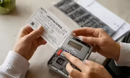 two persons holding up a piece of paper with a visa