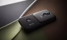 an open camera phone sitting on top of a green and black table