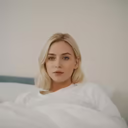 a woman laying in bed with her arms folded