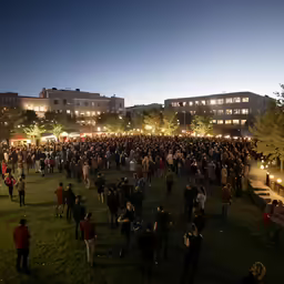 a group of people are gathered around some buildings