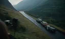 a car drives along a winding road beside a river