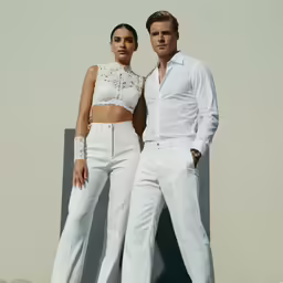 two women in white pants posing for the camera