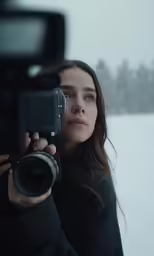 a woman in the cold takes a photograph