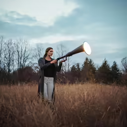 a person standing in a field with a big horn