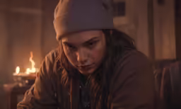 a close up of a person in a room near a fireplace