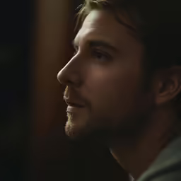a man with long hair looking off to his side