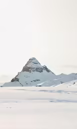 snowy mountains and plain with one person walking