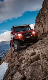 the car is traveling down the rocky trail