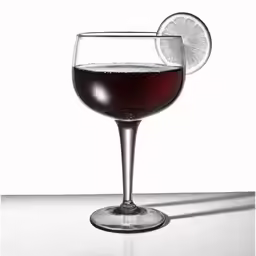 a wine glass filled with liquid and topped with a slice of lemon