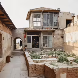 a man is standing outside of an old stone house