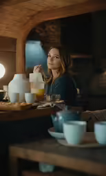 a woman sitting at a table with coffee in front of her