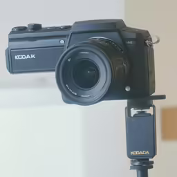 the kodak camera mounted to a tripod holding an external digital flash drive