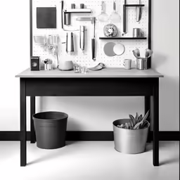 a black and white photo of a small table with dishes, cups, spoons and pots