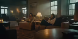 two people sitting on couches with lamps in the corner