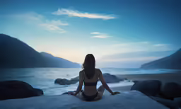 the girl is sitting on the rocks by the water
