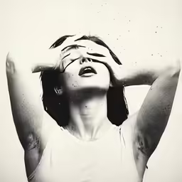 a woman with her hands on her head is looking up