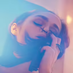 an artistic photo of a woman leaning and leaning against a wall with her head propped up to her ear