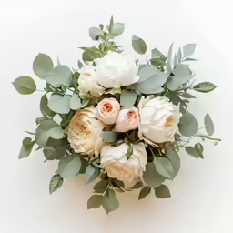 a bouquet with white and pink flowers sits on top of the white surface