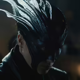 the dark knight of gotham looks angry while dressed in black leather