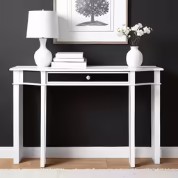 a white table with a lamp, a plant and two vases