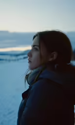the young woman is standing alone on the snow