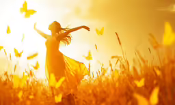 the woman is standing in a field of wheat