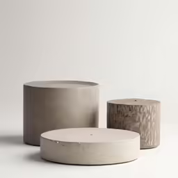 three concrete cylinders with different designs, each on a pedestal