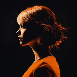 woman in orange shirt looking away on black background,the woman has an orange top on her shoulders