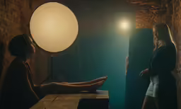 a woman sitting down in a dimly lit room