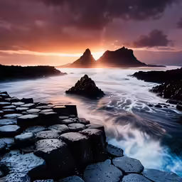 the ocean with rocks, waves, and the sky in the background