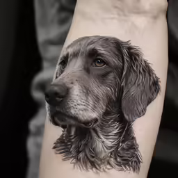 the black and grey drawing of a dog has been inked onto the right side of the arm