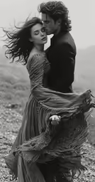 the beautiful couple is embracing by a mountain