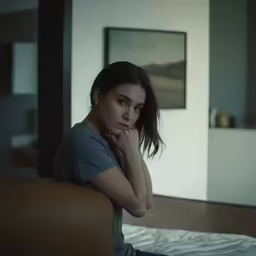 a girl sits on her bed in the dark